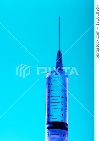 Vertical image of close up of syringe with needle and copy space on blue background Vertical image of close up of syringe with needle and copy space on blue background 121019957