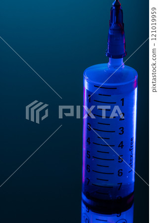Vertical image of close up of syringe with needle and copy space on blue background Vertical image of close up of syringe with needle and copy space on blue background 121019959