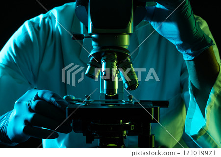 Scientist using microscope and copy space on black background Scientist using microscope and copy space on black background 121019971