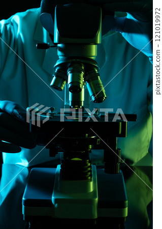 Vertical image scientist using microscope and copy space on black background 121019972