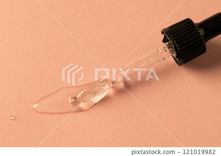 Close up of pipette with drop and copy space on pink background Close up of pipette with drop and copy space on pink background 121019982