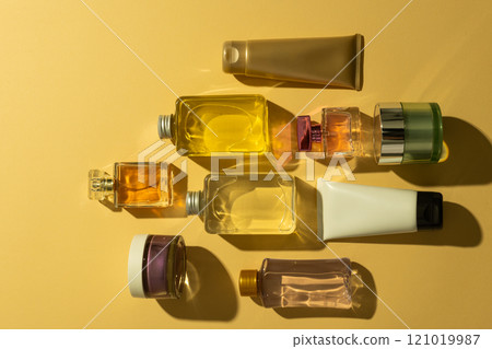 Flat lay of beauty products bottles, tub and tube with copy space on yellow background 121019987