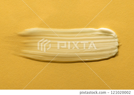 Close up of beauty product white cream smudge with copy space on yellow background Close up of beauty product white cream smudge with copy space on yellow background 121020002