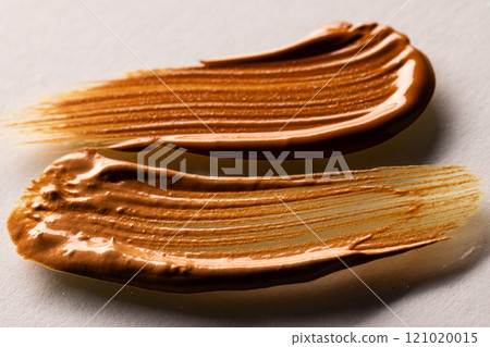 Close up of beauty product brown cream foundation smudges with copy space on white background Close up of beauty product brown cream foundation smudges with copy space on white background 121020015