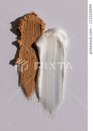 Close up of beauty product white and brown cream smudges with copy space on white background 121020044