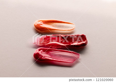 Close up of beauty product red, pink and orange lipstick smudges with copy space on white background 121020060
