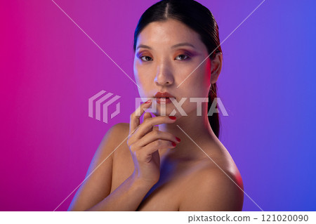 Portrait of asian woman wearing purple eye shadow and red nail polish on purple background 121020090