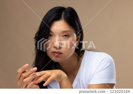 Portrait of asian woman wearing natural makeup and white t-shirt on beige background Portrait of asian woman wearing natural makeup and white t-shirt on beige background 121020184