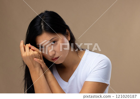Portrait of asian woman wearing natural makeup and white t-shirt on beige background 121020187