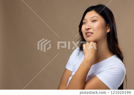 Portrait of asian woman wearing natural makeup and white t-shirt on beige background, copy space Portrait of asian woman wearing natural makeup and white t-shirt on beige background, copy space 121020199