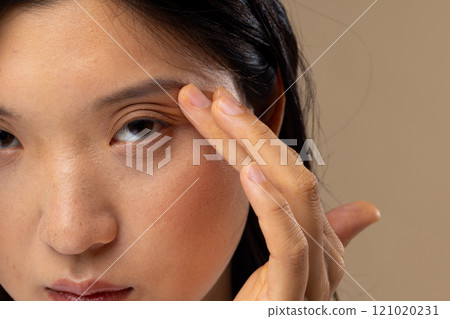 Portrait of asian woman wearing natural makeup on beige background Portrait of asian woman wearing natural makeup on beige background 121020231