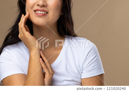 Asian woman wearing natural makeup and white t-shirt on beige background Asian woman wearing natural makeup and white t-shirt on beige background 121020240