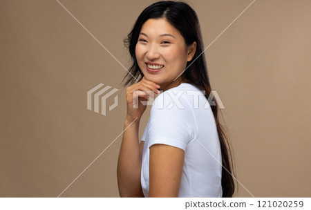 Portrait of asian woman wearing natural makeup and white t-shirt on beige background, copy space Portrait of asian woman wearing natural makeup and white t-shirt on beige background, copy space 121020259