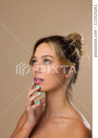 Caucasian woman wearing natural makeup and blue nail polish on beige background, copy space Caucasian woman wearing natural makeup and blue nail polish on beige background, copy space 121020261