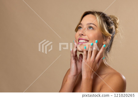 Caucasian woman wearing natural makeup and blue nail polish on beige background, copy space Caucasian woman wearing natural makeup and blue nail polish on beige background, copy space 121020265