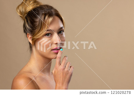 Portrait of caucasian woman wearing blue nail polish on beige background, copy space Portrait of caucasian woman wearing blue nail polish on beige background, copy space 121020278