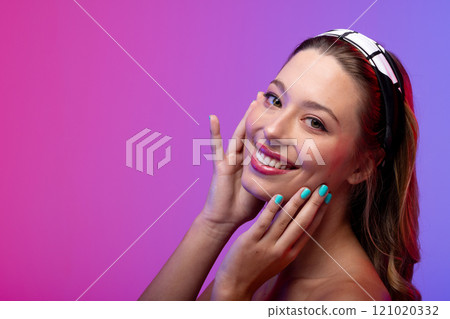 Portrait of caucasian woman wearing blue nail polish on purple background, copy space Portrait of caucasian woman wearing blue nail polish on purple background, copy space 121020332