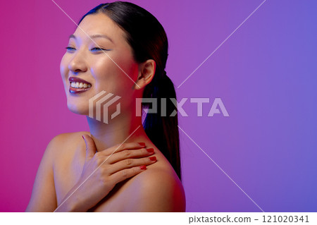 Asian woman wearing blue eyeliner and red nail polish on purple background, copy space Asian woman wearing blue eyeliner and red nail polish on purple background, copy space 121020341