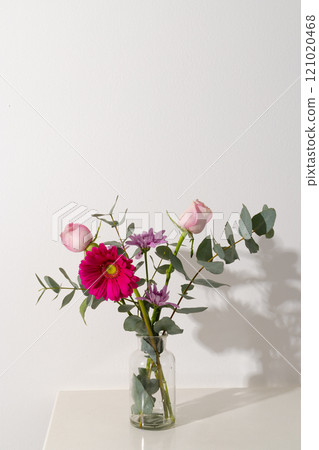Vertical image of pink flowers in glass vase and copy space on white background Vertical image of pink flowers in glass vase and copy space on white background 121020468