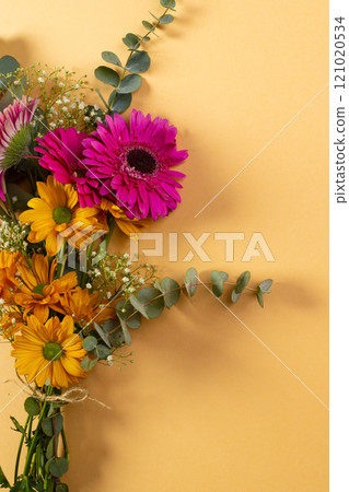 Vertical image of bunch of pink and yellow flowers with copy space on yellow background Vertical image of bunch of pink and yellow flowers with copy space on yellow background 121020534