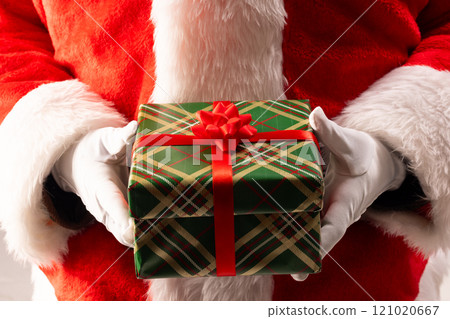 Santa claus holding christmas present with copy space on black background Santa claus holding christmas present with copy space on black background 121020667