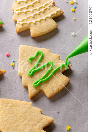Vertical image of decorating of christmas cookies with copy space on grey background Vertical image of decorating of christmas cookies with copy space on grey background 121020704