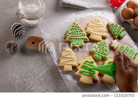 African american woman hand decorating christmas cookies with copy space 121020705