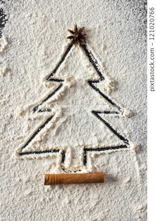 Vertical image of anis seed and christmas tree shape in flour with copy space on black background Vertical image of anis seed and christmas tree shape in flour with copy space on black background 121020766