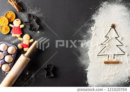 Anis seed and christmas tree shape in flour, eggs, roller with copy space on black background 121020769