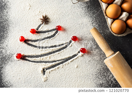 Anis seed and christmas tree shape in flour, eggs, roller with copy space on black background 121020770