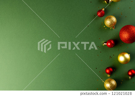 Christmas red and gold baubles with copy space on green background Christmas red and gold baubles with copy space on green background 121021028