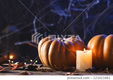 Pumpkins, candle and spiderweb decorations with copy space on black background 121021061
