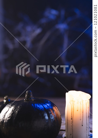 Vertical image of pumpkin and candle with copy space on dark background 121021081