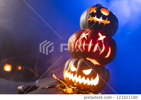 Carved pumpkins with copy space on blue background Carved pumpkins with copy space on blue background 121021180