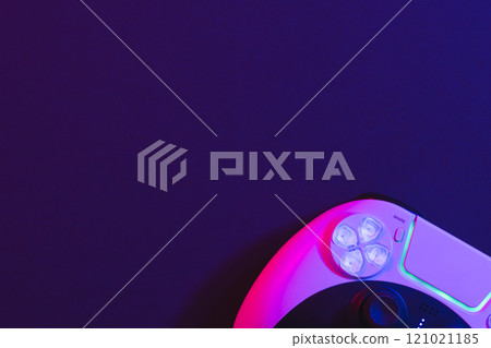 Composite of video game pad and copy space on neon background Composite of video game pad and copy space on neon background 121021185