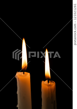 Two lit white candles with copy space on black background 121021281