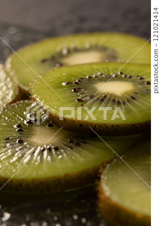 Micro close up of sliced kiwi fruit and copy space on black background 121021414