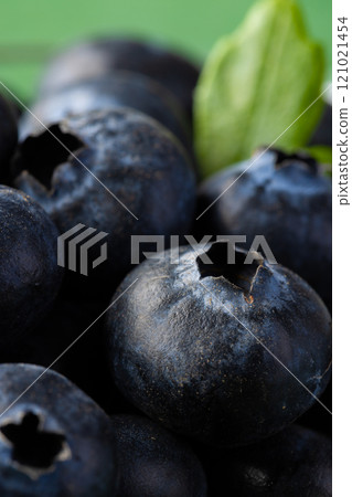 Micro close up of blueberries with copy space on green background 121021454