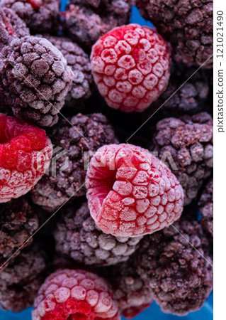 Micro close up of frozen raspberries with copy space on blue background 121021490