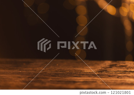 Yellow bokeh blurred lights with copy space and wooden surface on dark background 121021801