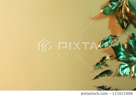 Metallic gold autumn leaves with copy space on orange background 121021906