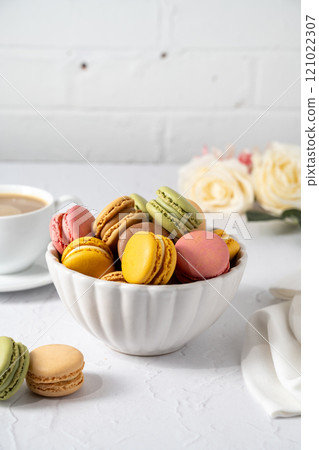 Macarons colorful cookies with cup of coffee, stack of french macarons in a plate. Sweet dessert Macarons colorful cookies with cup of coffee, stack of french macarons in a plate. Sweet dessert 121022307