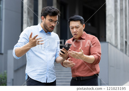 Two men appear concerned as they look at a smartphone screen, surprised and perplexed. Their expressions suggest confusion or unexpected news, engaging in conversation, likely about a tech problem. 121023195
