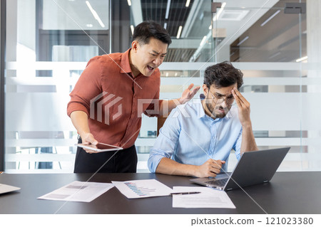 A business scenario depicting an angry boss confronting a stressed employee in a modern office setting. The scene highlights workplace conflict, stress, and communication issues between colleagues. 121023380