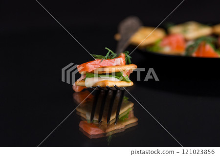 small snack canapes with crackers and lightly salted red fish Salmon, isolated on black background small snack canapes with crackers and lightly salted red fish Salmon, isolated on black background 121023856