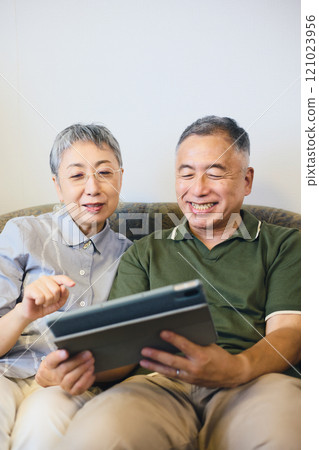 Senior couple enjoying content on a tablet 121023956