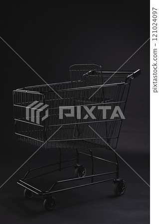 Vertical image of shopping trolley with copy space over black background 121024097
