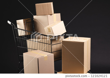 Shopping trolley with boxes and copy space over black background 121024121