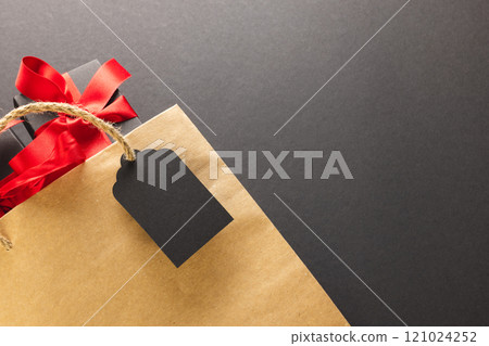 Gift boxes with ribbon, gift bag with copy space over black background Gift boxes with ribbon, gift bag with copy space over black background 121024252