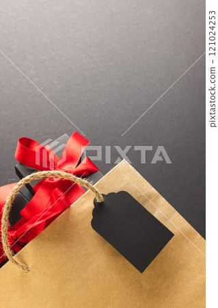 Vertical image of gift boxes with ribbon, gift bag with copy space over black background Vertical image of gift boxes with ribbon, gift bag with copy space over black background 121024253